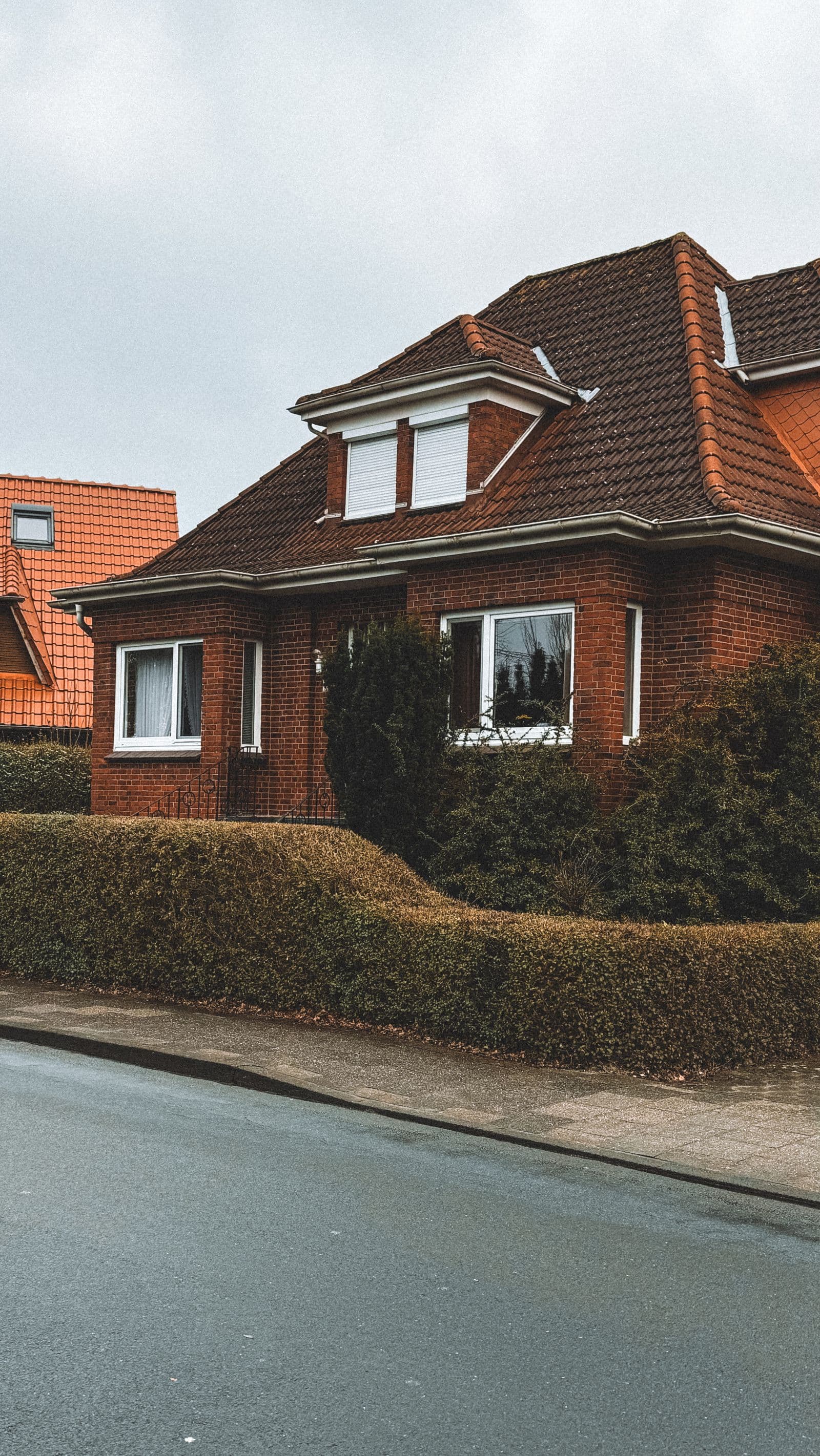 A suburban brick home with a chimney on the side wall