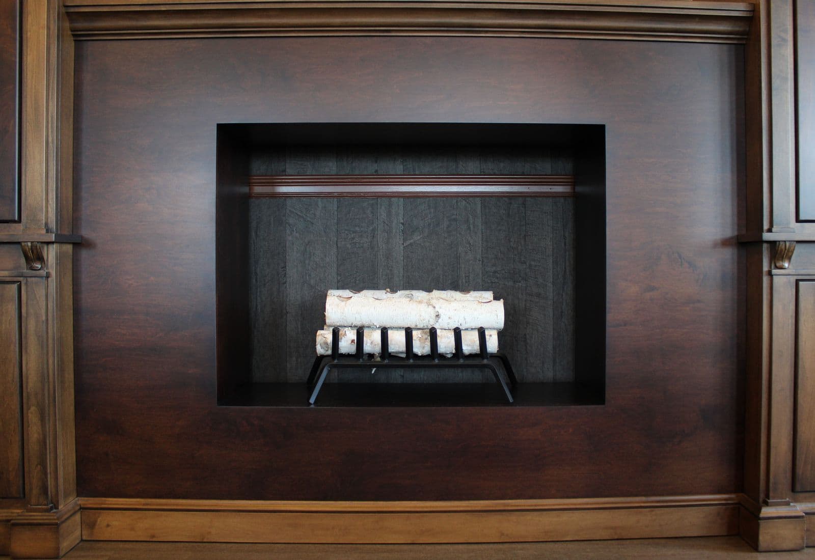 Birch logs stacked beside a fireplace