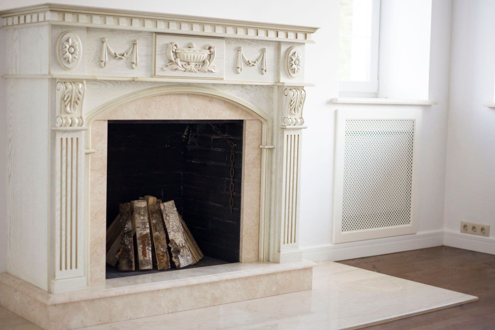 A classic fireplace with firewood stacked alongside