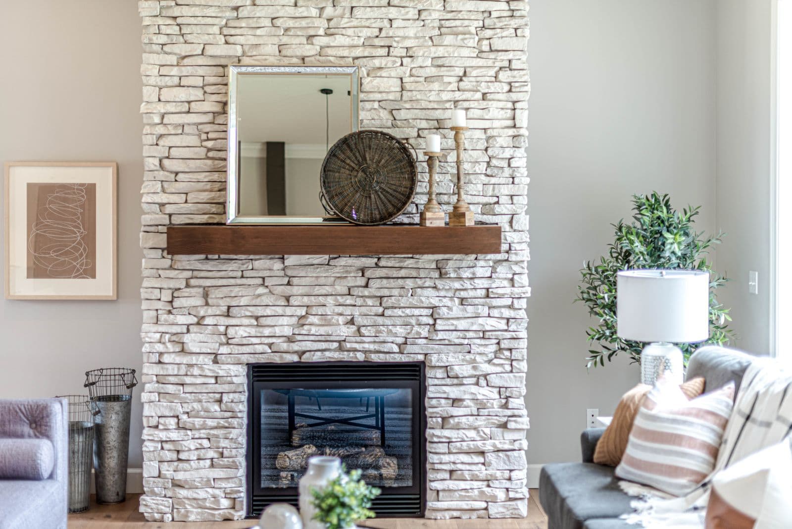 A cozy stone fireplace with a fire burning
