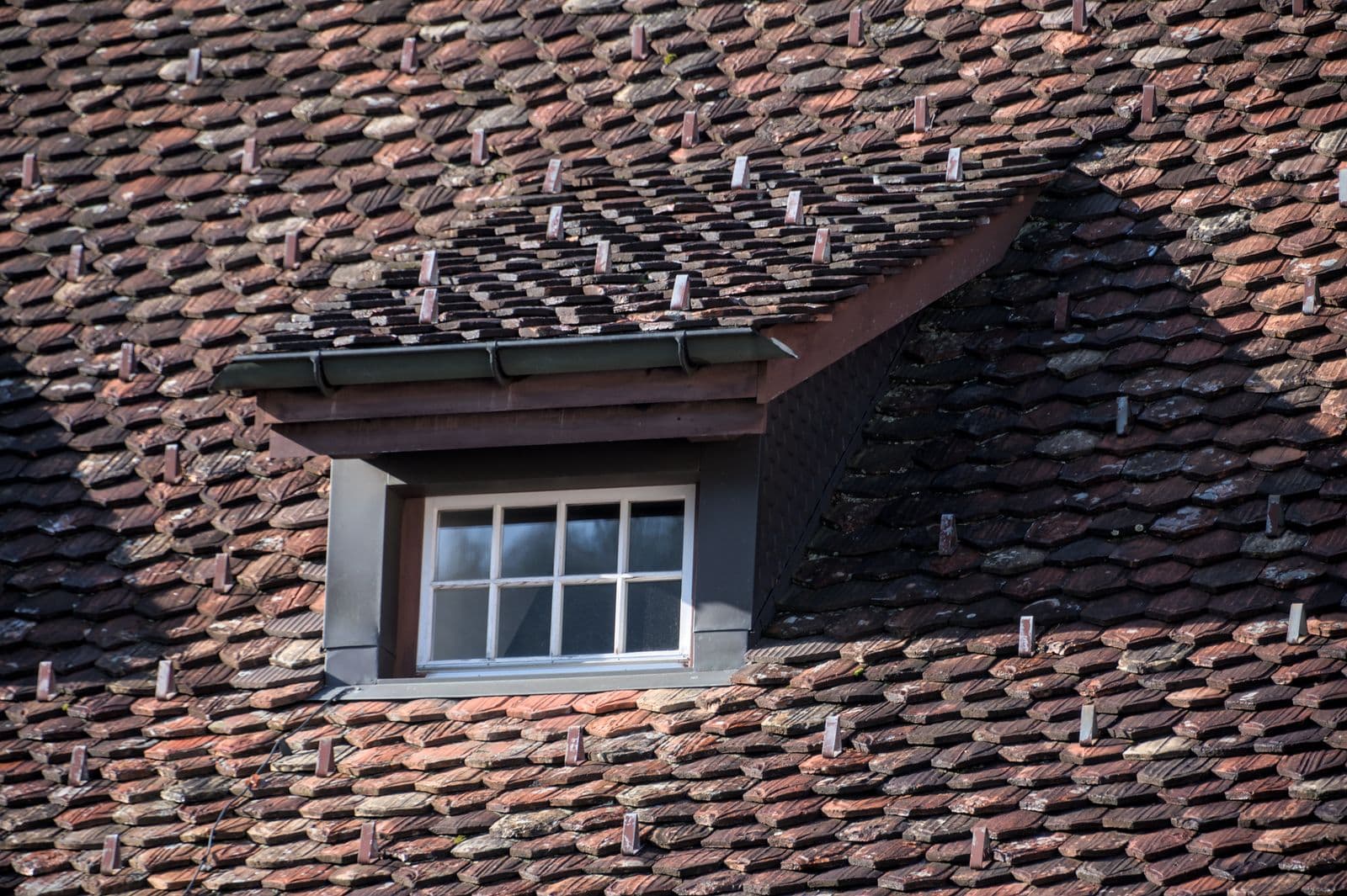 A vintage dormer window set into a pitched roof