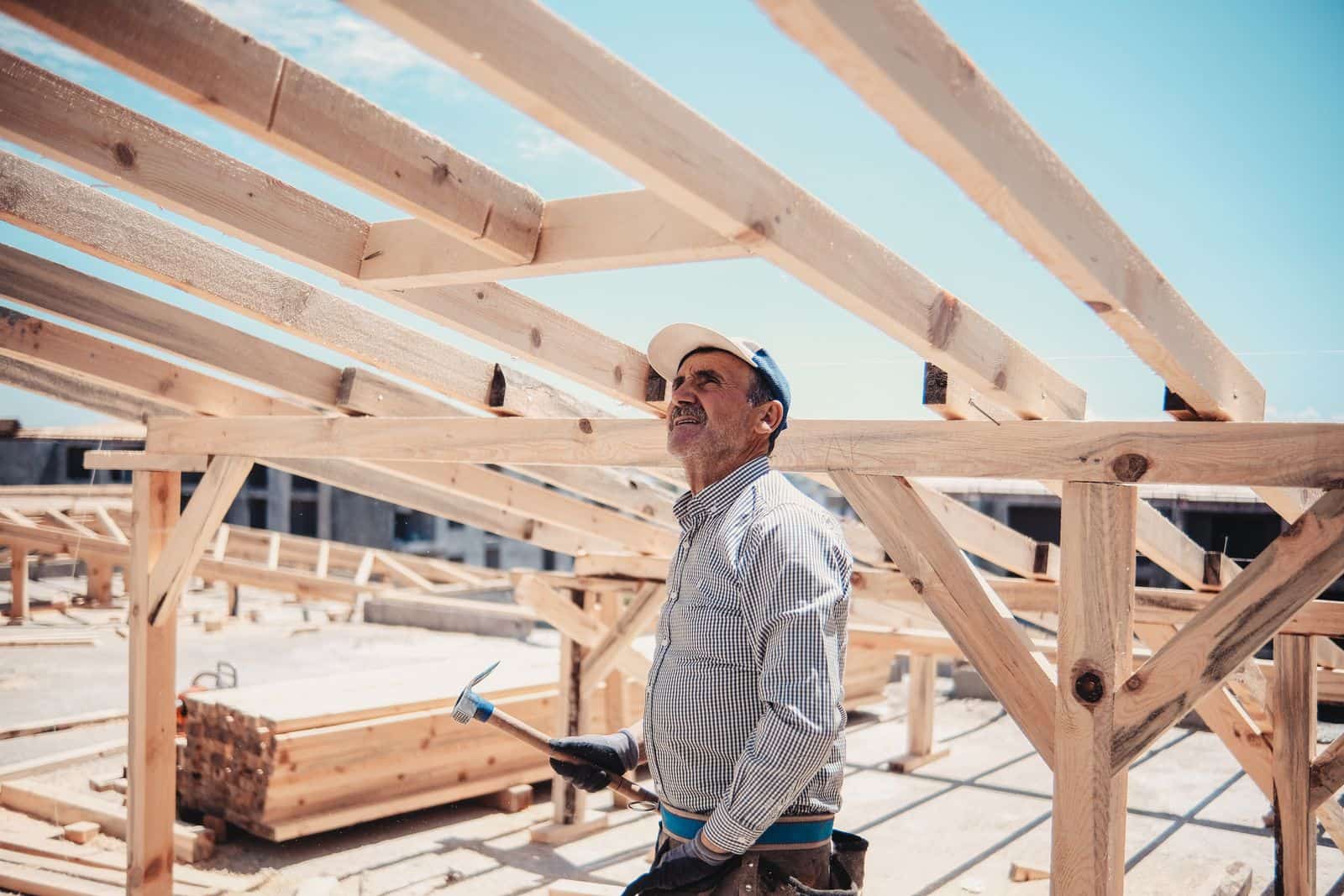 A worker inspecting roof framing timbers