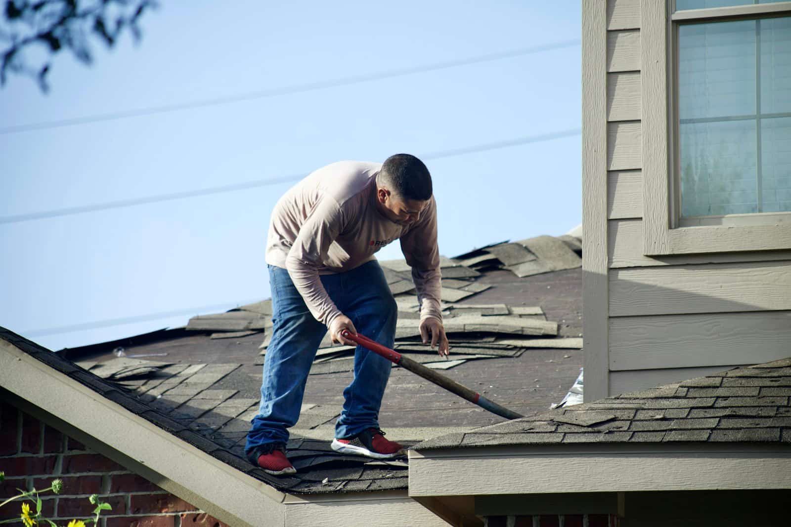 A chimney sweep working at the top of a chimney